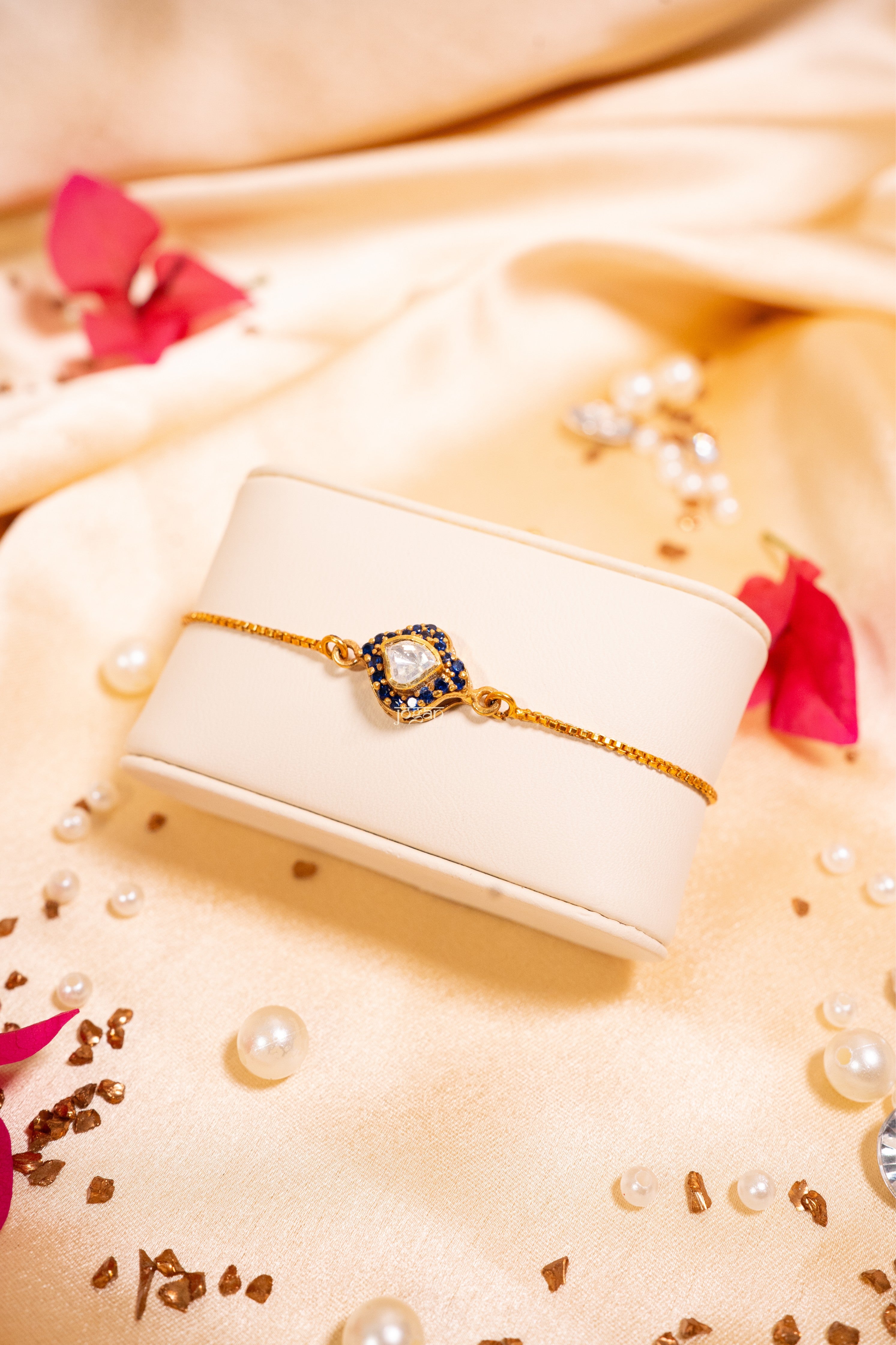 Adjustable gold-plated 92.5 sterling silver bracelet with lab grown polki and sapphire-like stones, bell and evil eye-inspired festive design
