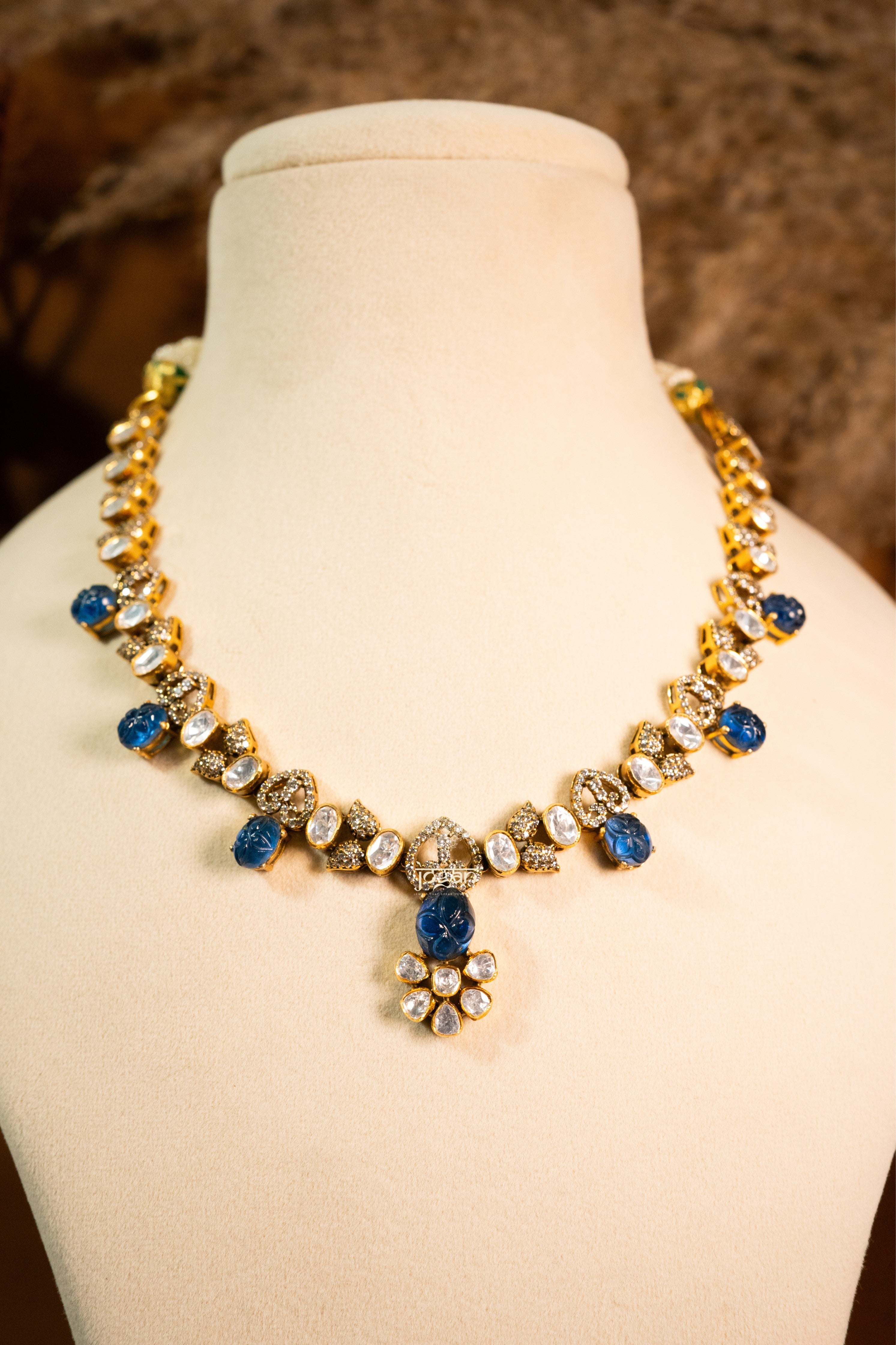 Indraneel necklace set with lab grown polkis, gold-plated 92.5 sterling silver and deep blue carved semi-precious stones, inspired by royal Indian heritage.
