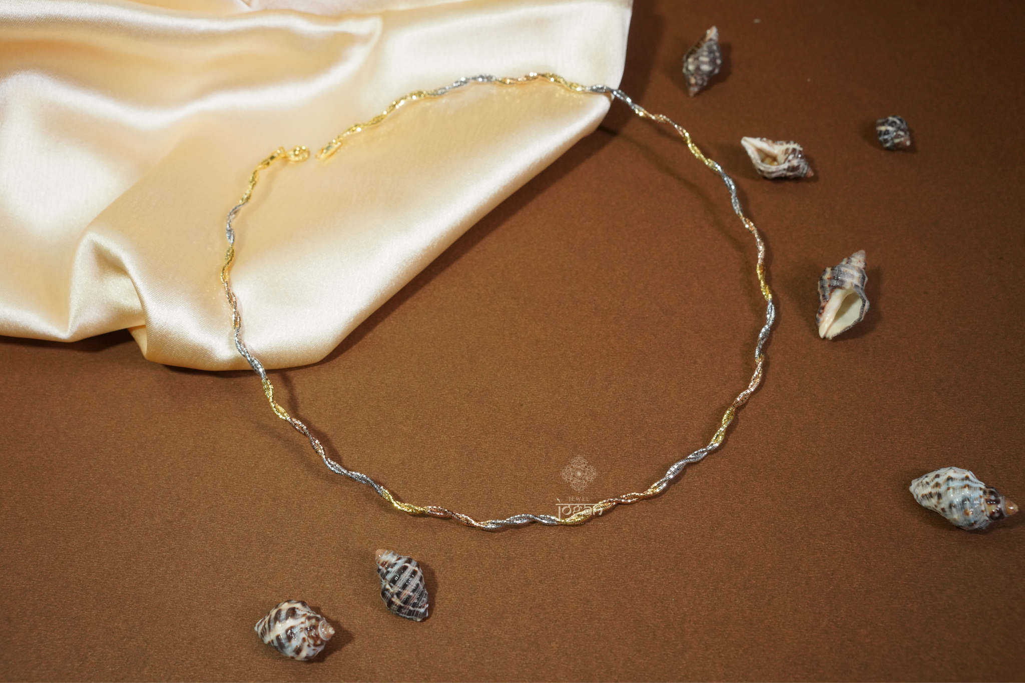 Curved Hasli chain with Italian craftsmanship, featuring a twisted tri-tone design in gold, rhodium, and rose finishes. A high-quality, durable, and elegant piece ideal for both everyday styling and special occasions.