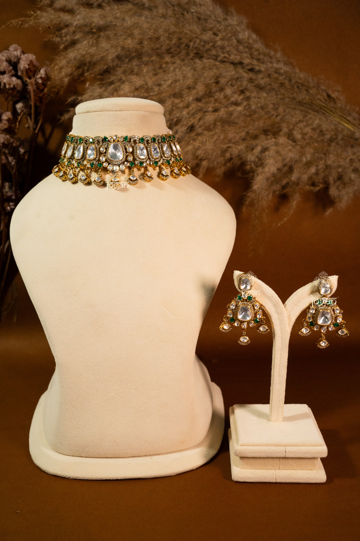 Sitabani Necklace Set by Jewel Jogan — handcrafted choker necklace and matching earrings in 92.5 sterling silver with gold plating. Features lab-grown polkis and emerald-toned semi-precious stones, offering a regal green-and-gold look. Perfect for brides, wedding guests, and festive occasions seeking traditional yet contemporary elegance.
